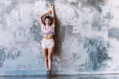 Kız bir duvar elle çizim soyut bir arka plan üzerinde duruyor