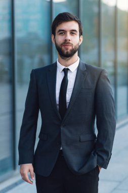 Bir bina karşı genç bir işadamı portresi. Cep elinde tutar