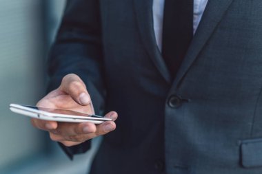 Elbiseli bir smartphone kullanarak bir iş adamı. Arama ve sosyal ağlar kavramı. Yakın çekim