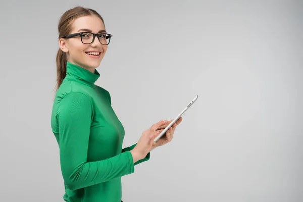 Bir tablet onun elinde tutan ve gülümseyen neşeli profil kız