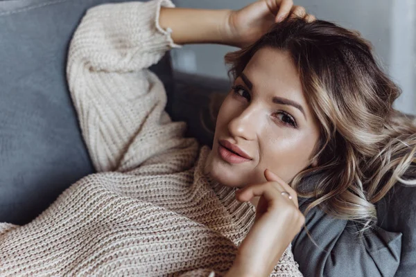 Modern bir güzel kadın kanepede yatan closeup. Kameraya bak