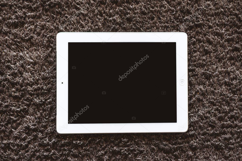 Tablet mockup lying on the floor on the carpet. Indoors in the center