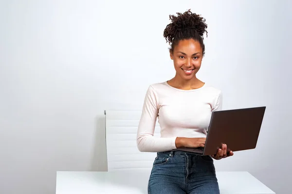 Alegre mulata chica tener un descanso de pie en la oficina sosteniendo un portátil — Foto de Stock