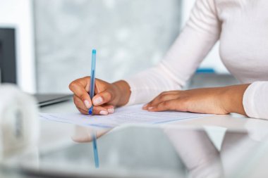 Closeup female hands during writing with pen on a paper, business woman signing a document clipart