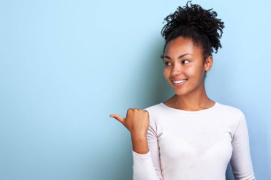 Çekici genç mulatto kadın kopya alanı için parmağını yana doğru işaret