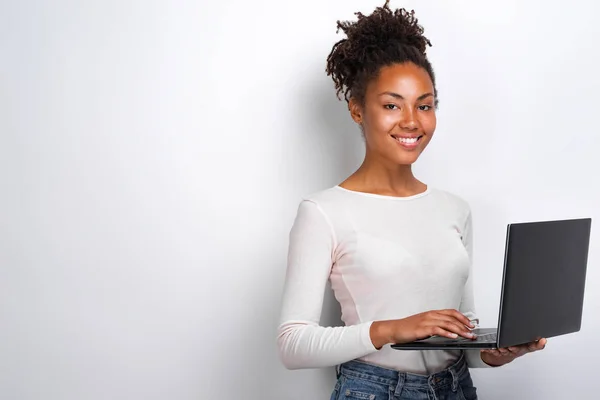 Retrato de jovem mulher feliz segurando computador portátil sobre fundo branco — Fotografia de Stock