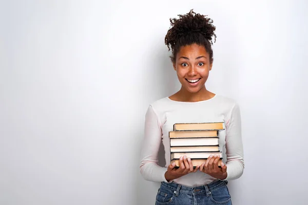 Portrét vzrušené mladé dívky držící knihy na bílém pozadí. Zpět do školy — Stock fotografie