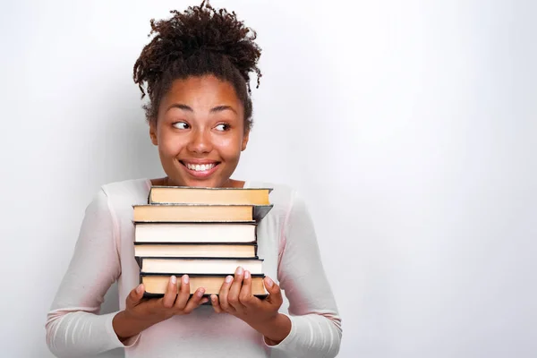 Portrét šťastné a hloupé dívky držící na bílém pozadí knihy. Zpět do školy — Stock fotografie