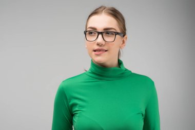 Kız mütevazı bir şekilde giyinmiş dudağını ısırarak yan lara bakıyor. 