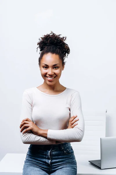 Sorrindo Menina Apoiou Uma Mesa Com Laptop Fundo Parede Branca — Fotografia de Stock