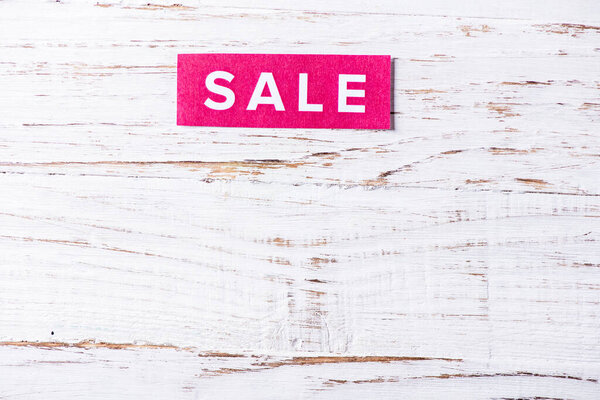 For Sale sign on white wooden background