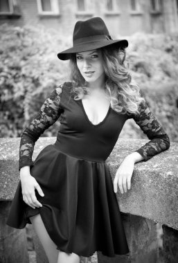 Büyük siyah şapka ve dantel kollu bluz ile sevimli genç hafif kahverengi saçlı esmer kadın. Kıvırcık saçlı poz ile seksi güzel genç bir kadın. Güzel uzun saçlı seksi bir kadın portresi