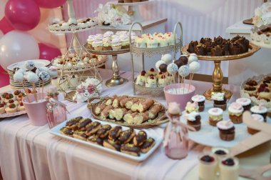 Düğün dekorasyon pastel ile cupcakes, meringues, kekler ve macarons renkli. zarif ve lüks olay renkli kurabiye aranjmanı. Düğün tatlı macaroons ile