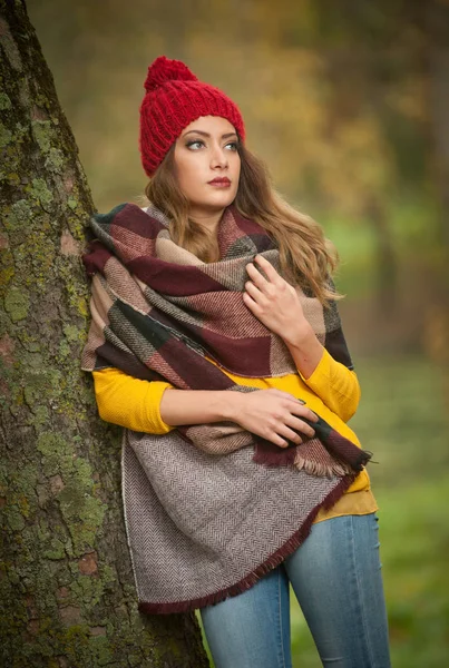 赤い帽子とスカーフと黄色のプルオーバー秋の公園 赤い緑黄色 列縦隊で美しい若い白人女性の幸せな肖像画のファッション 季節や人のコンセプトです 秋のライフ スタイル — ストック写真