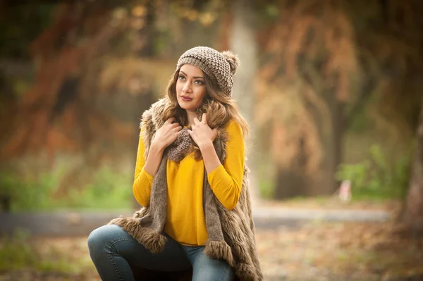 一个美丽的年轻的高加索妇女与红色的帽子和围巾和黄色的套头衫在秋天的公园 红色绿色黄色三的快乐肖像时尚 季节和人的概念 秋季生活方式 — 图库照片