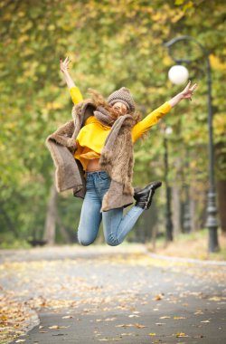Gri bir şapka ve eşarp ve sonbahar parkı sarı pullover ile güzel bir genç Kafkas kadının Happy Portrait moda, kırmızı yeşil sarı üçlü. Sonbahar, mevsim ve insan kavramı. Sonbahar yaşam tarzı