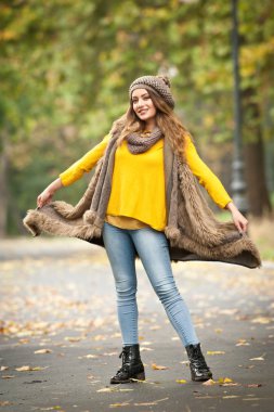 Gri bir şapka ve eşarp ve sonbahar parkı sarı pullover ile güzel bir genç Kafkas kadının Happy Portrait moda, kırmızı yeşil sarı üçlü. Sonbahar, mevsim ve insan kavramı. Sonbahar yaşam tarzı
