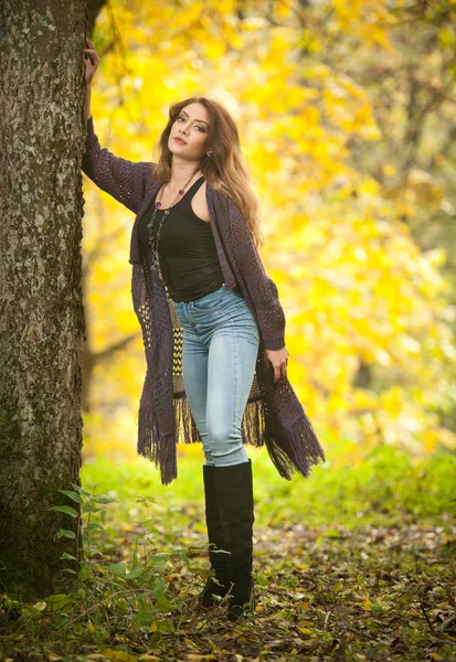 秋の公園で長い髪 ストレートジーンズと長い黒いブーツを持つ美しい官能的な若い白人女性の幸せな肖像画ファッション 人々のコンセプト 秋のライフスタイル — ストック写真