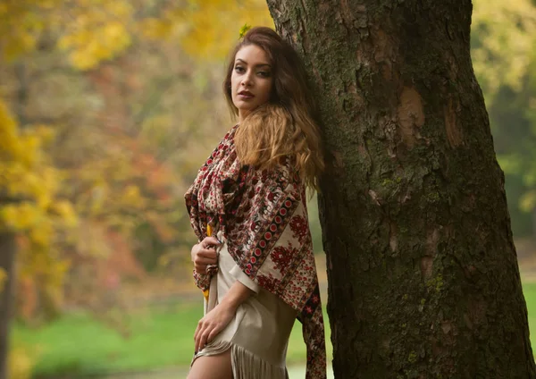 一个美丽的年轻白种妇女与围巾 长腿和黄色拉扯在秋天公园 红绿黄三 季节和人的概念 秋季生活方式 — 图库照片