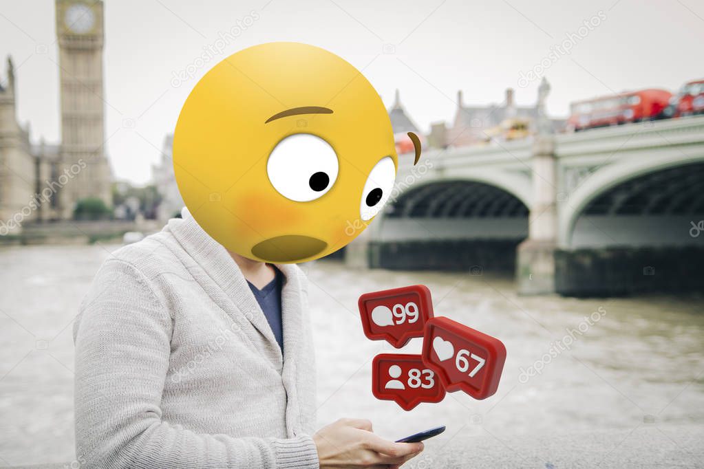 man with emoji head surprised looking at smartphone at London city