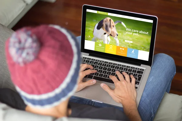 Junger Mann auf dem Sofa pet website — Stockfoto