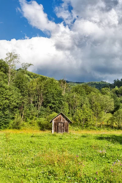 木の小屋と青い空に白い雲と山の風景 — ストック写真