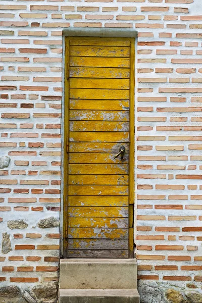 Старі дерев'яні двері на цегляній стіні — стокове фото