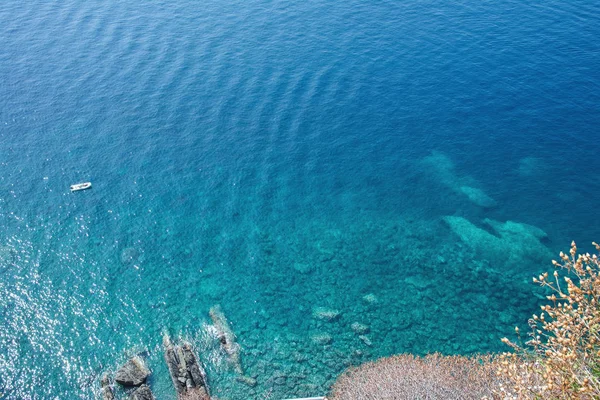 Deniz yüzeyi ve kaya görünümü. Bir deniz manzarası ile arka plan. Turkuaz deniz suyunun tüm tonları. Cinque Terre Sahili.