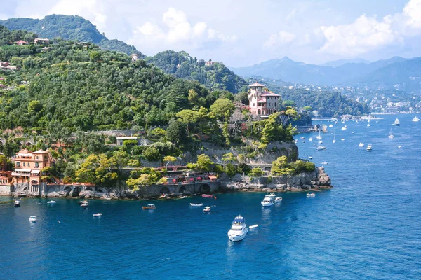 Hermosa vista aérea de la luz del día desde la parte superior a los barcos en el agua, casas coloridas y villas en Portofino ciudad de Italia. Turistas caminando por la acera . — Foto de Stock