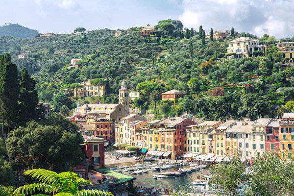 Portofino, Liguria, Italy: 09 august 2018. Portofino landscape, best touristic Mediterranean place with colorful houses, fishing boats and luxury yacht, picturesque harbor.