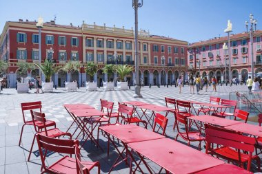 Nice'deki merkez meydan, Provance, Alpes, Cote d'Azur, Fransızca 31 Temmuz 2018; Ön planda kırmızı masa ve sandalyeler ile Nice Place Massena meydanının bir görünümü. 