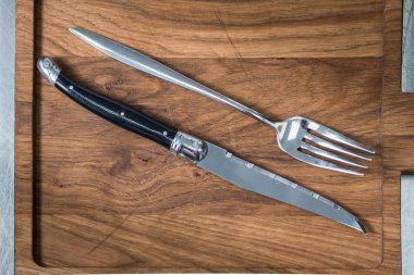 Mutfak bıçak ve çatal bir kesme tahtası üzerinde yerleştirilir