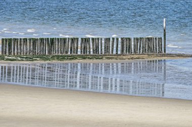 Sığ sularda yansıtan bazalt dalgakıran ahşap yığınları, Breskens, Hollanda beach oteller