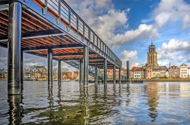 Low view across the IJssel river towards the city of Deventer, The Netherlands and the new ferry pier, constructed on the location of the historic pontoon bridge clipart