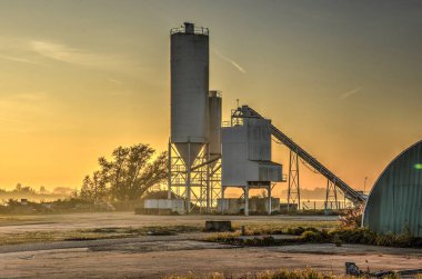 Barendrecht, Hollanda, 1 Kasım 2015: Gün batımında Oude Maas Nehri'nin kıyısında, küçük grainsilo