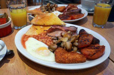 Tam İngiliz kahvaltısı iki, sahanda yumurta, tost, mantar, domates, sosis, patates ve portakal suyu kuru fasulye