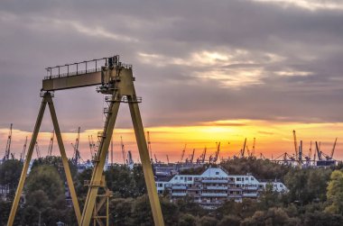 Rotterdam, Hollanda, 12 Ekim 2018: 1980 Charloisse Hoofd, günbatımında liman vinçler tarafından çevrili, konut bina