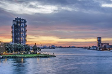 Rotterdam, Hollanda, 12 Ekim 2018: Nieuwe Maas nehri liman teçhizatları ve güneş battıktan sonra kısa bir süre kendi bankalarında konut kuleleri ile