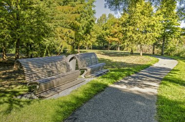 Utrecht, Hollanda, 27 Eylül 2018: iki Ahşap banklar çimenler ve ağaçlar Maximapark grupları aracılığıyla sonbaharda kıvrımlı bir patika boyunca