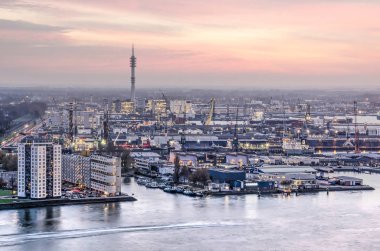 Rotterdam, Hollanda, 12 Kasım 2018: konut ve günbatımı pembe bir gökyüzü altında Waalhaven liman çevresinde liman yüklemeleri