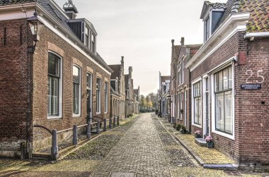 Hindeloopen, Hollanda, 4 Kasım 2018: eski şehir caddelerinden birinin bakış açısı azalan ile görünüm evler tek katlı tuğla ile kaplı