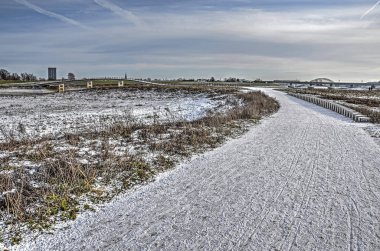 Nereye götürecek bir yol taşları adım boyunca ve zarif bir beton köprü boyunca Hollanda, Nijmegen şehir yakındaki taşkın yatağının kapsayan kar ince bir tabaka