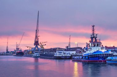 Rotterdam, Hollanda, 27 Aralık 2018: mavi ve mor bir gökyüzü günbatımı depolar, vinçler ve Merwehaven liman, gemi ile bir iskele üzerinde sonra