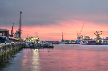 Rotterdam, Hollanda, 27 Aralık 2018: gemiler, vinçler ve ambarlar Inm4h alanında sadece güneş battıktan sonra renkli gökyüzü altında ışıklar devam