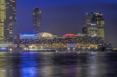 Rotterdam, Hollanda, 22 Aralık 2016: büyük cruiseship Wilhelminapier cruiseterminal ile onun modern highrise, mavi saat boyunca demirlemiş