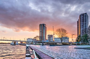 Rotterdam, Hollanda, 4 Aralık 2018: renkli gökyüzü günbatımı park ve quay adlı Leuvehoofd Nieuwe Maas Nehri'nin kıyısında