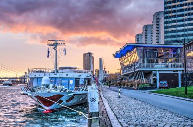 Rotterdam, The Netherlands, December 4, 2018: river cruise ship moored near the Boompjes pavillion under a colorful sky at sunset