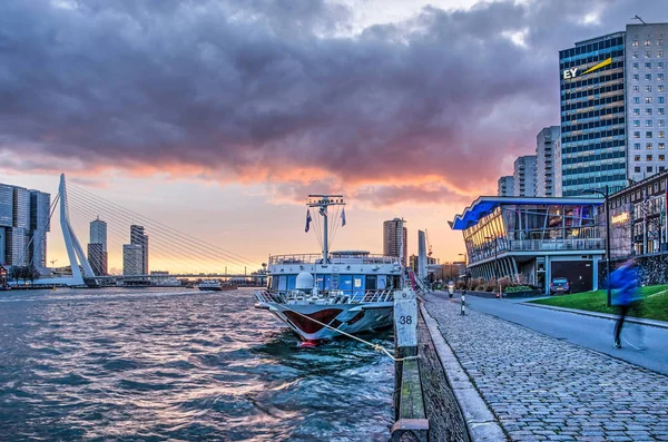 Rotterdam, Hollanda, 4 Aralık 2018: Nieuwe Maas nehri ve Boompjes quay, highrise binalar, Erasmus Köprüsü ve demirli bir nehir üzerinde dramatik günbatımı gökyüzü gemisi