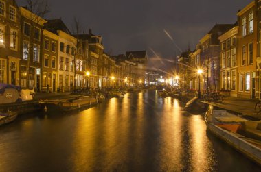 Leiden, Hollanda, 7 Ocak 2019: gece görünümü eski Ren Nehri/kanalı'nın tarihi evleri ve küçük tekne ile kaplı