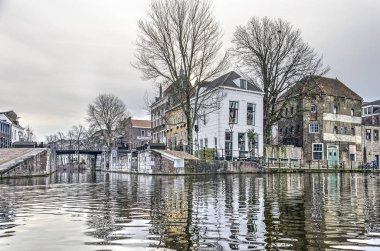 Schiedam, Hollanda, 27 Aralık 2018: Schie Nehri'nin suyunun sularından Yeni Sluice'ye doğru alçak görüş ve kışın bulutlu bir günde Uzun Liman'ın ötesinde